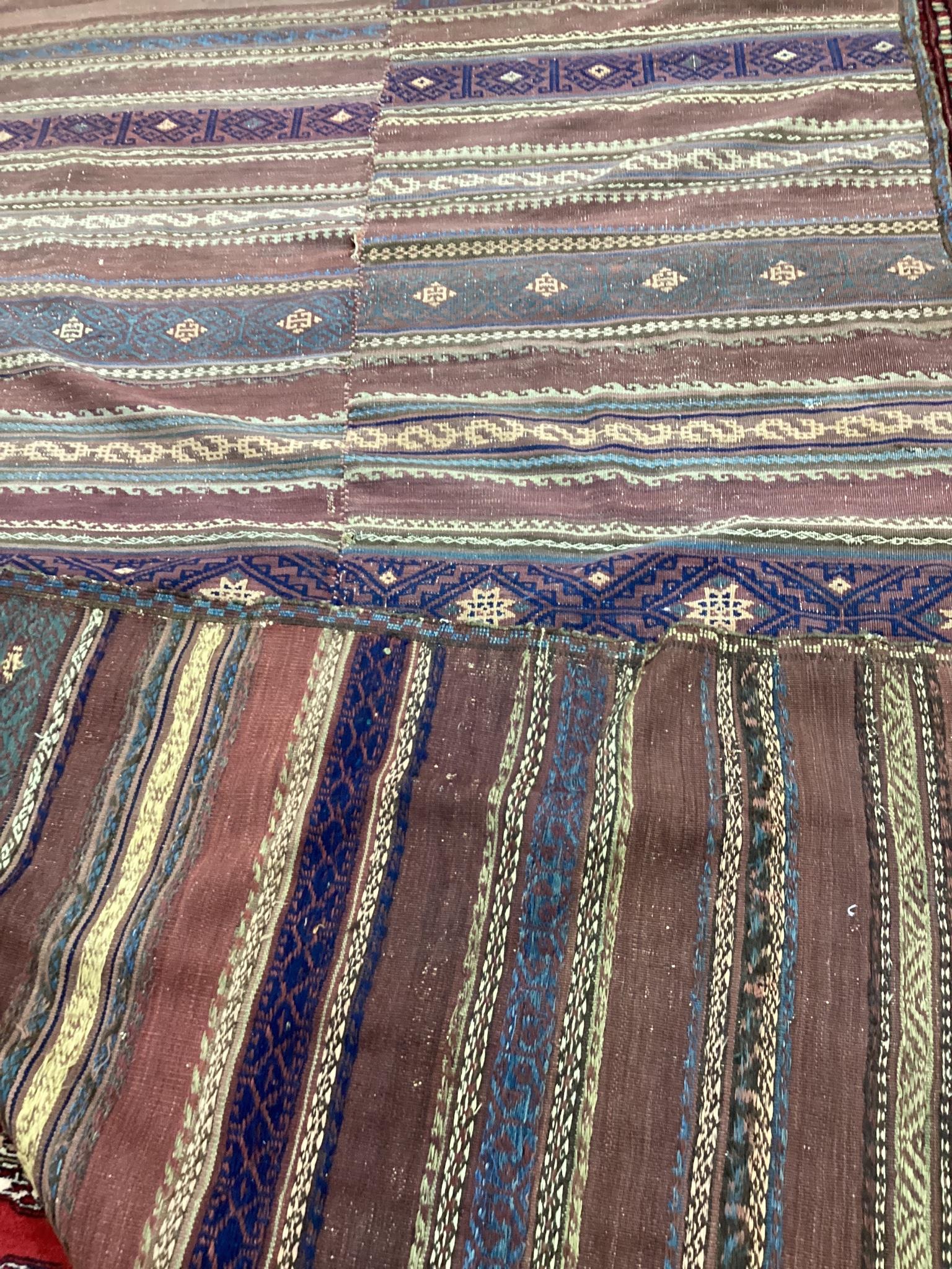 An antique polychrome flatweave carpet (cut centrally and re-stitched), 284 x 163cm